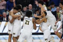 Men's basketball team celebrating after winning the final game