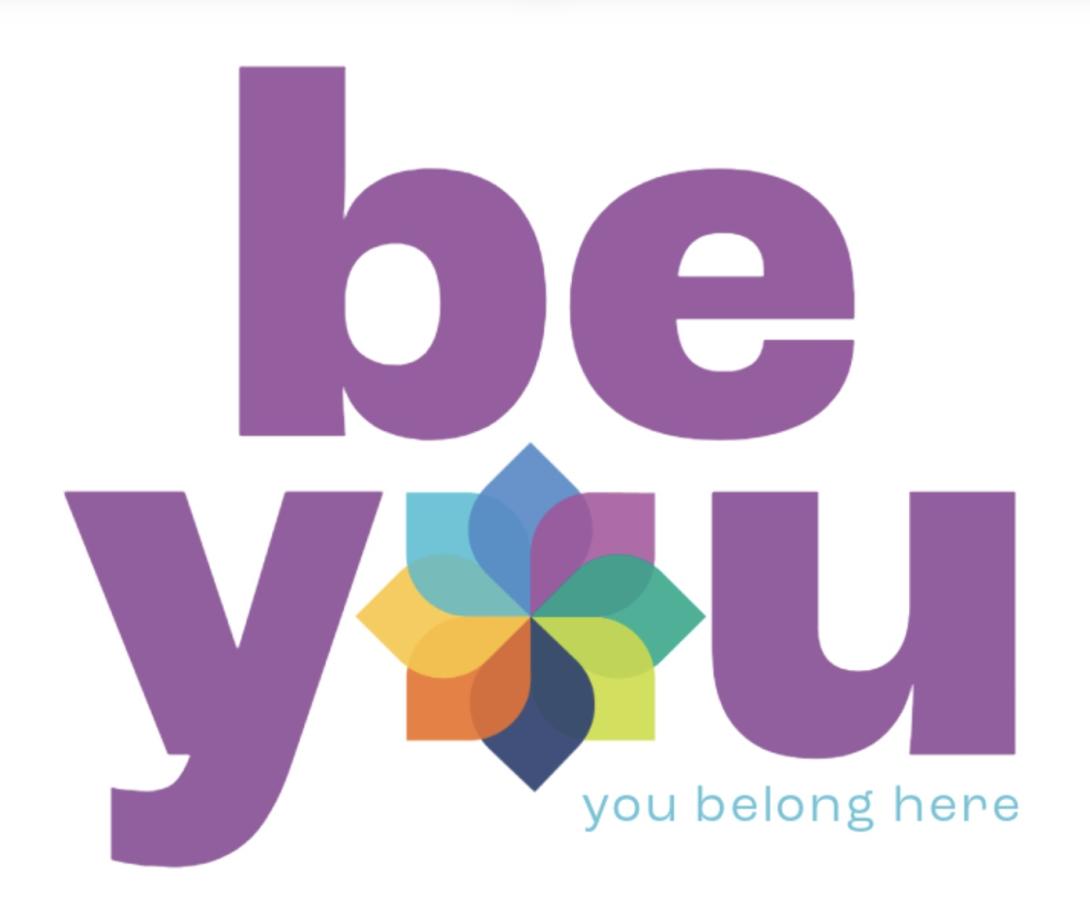 The text "be you: you belong here" with an illustration of the 8 dimensions of well-being in the shape of petals of different colors.