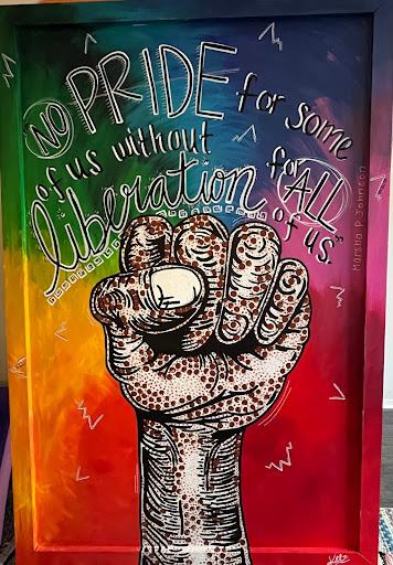Artist credit: Kelz.Creates. Illustration of a fist and the text "No pride for some of us without liberation for all of us" against a colorful background